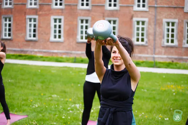 De kettlebell wordt boven het hoofd gedrukt